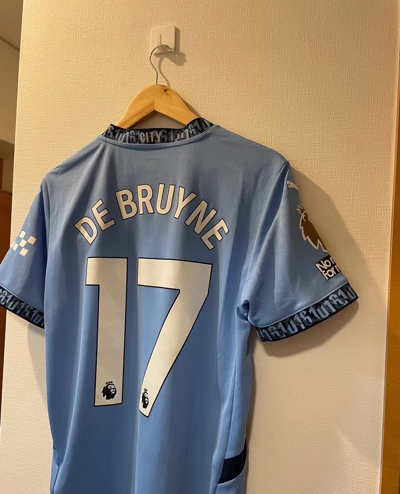 https://www.shopnogometni.com/wp-content/uploads/2025/04/Nogometni-dresi-Manchester-City.png